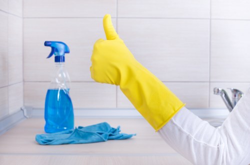 Staff member using protective gloves during oven cleaning